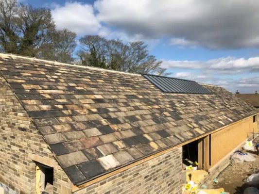 New roof using reclaimed stone roof slates.